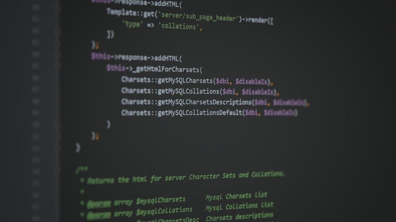 Gros plan sur un écran d’éditeur de code au fond sombre : des lignes de code PHP en couleurs, nettes au centre, floues sur les bords.