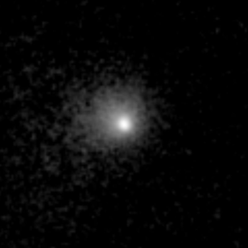 Image en noir et blanc : au centre, un point très brillant entouré d'un halo diffus qui s'estompe peu à peu dans un fond noir granuleux.