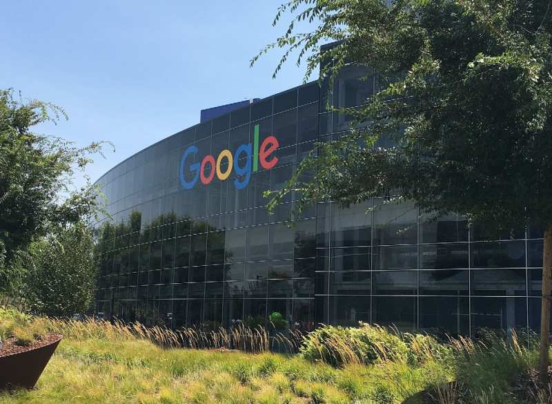 Façade vitrée d'un bâtiment du Googleplex, le siège de Google à Mountain View (Californie), avec le logo Google.