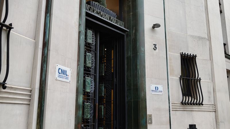Entrée d'un immeuble en pierre claire : une porte grillagée de bronze verdi ornée de bas-reliefs de navires, sous l'inscription « Ministère de la Marine marchande » ; à gauche, une plaque blanche « CNIL, Commission nationale informatique & libertés », à droite le numéro 3 et une plaque du Défenseur des droits.